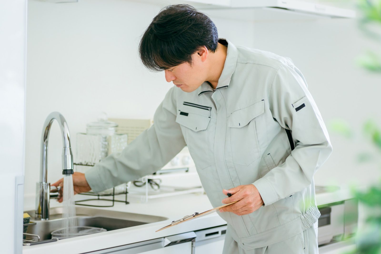 キッチンの蛇口を点検するスタッフ